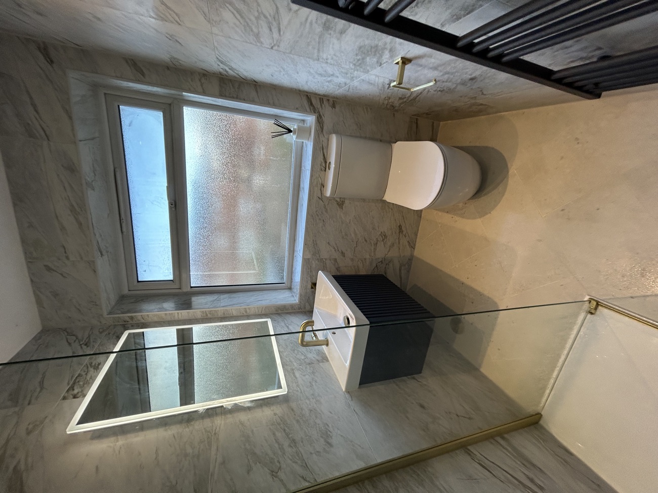 Marble cloakroom with navy vanity and chrome taps